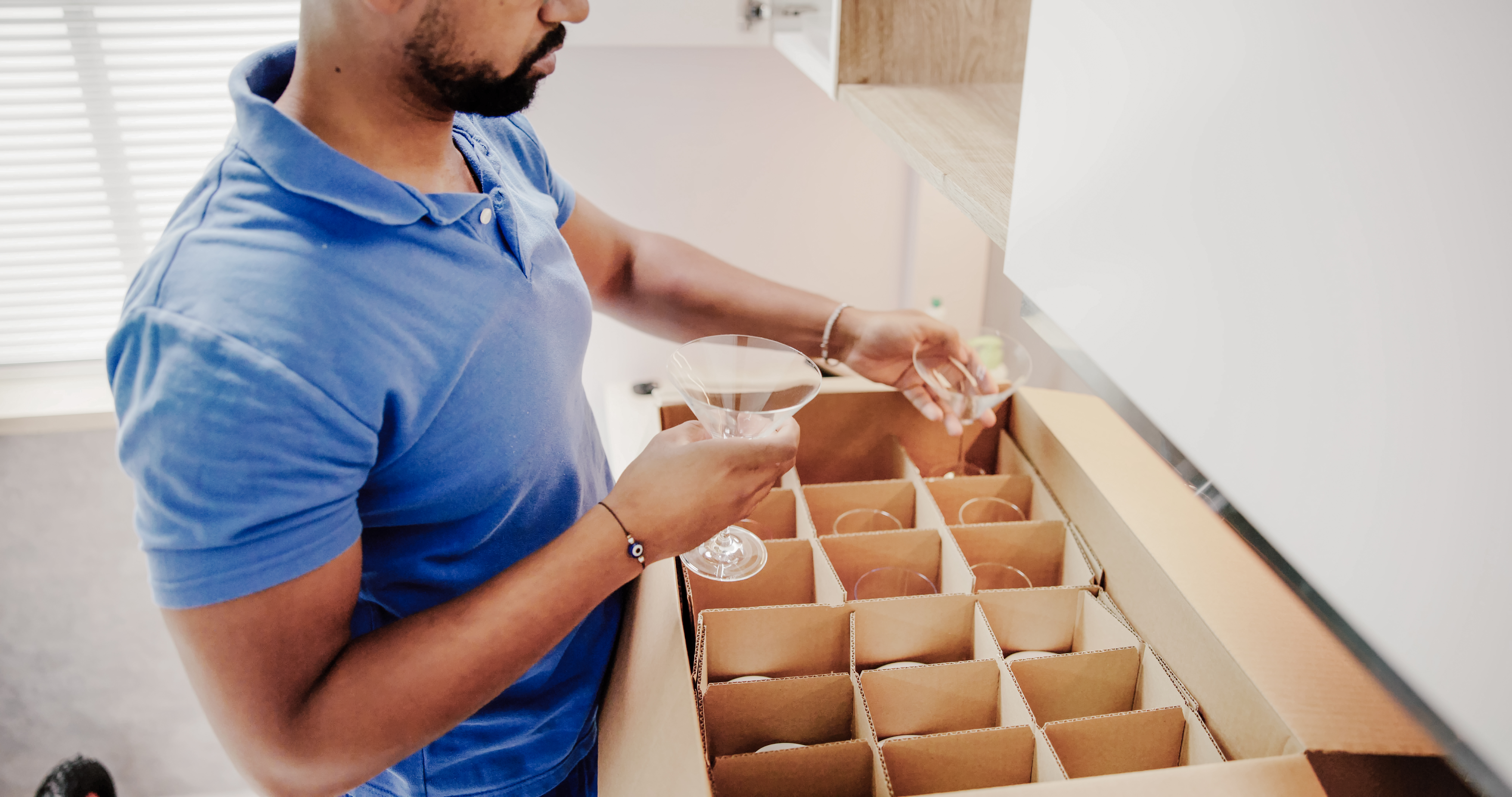 Packing Glasses At Home Apartment Room. Moving Service